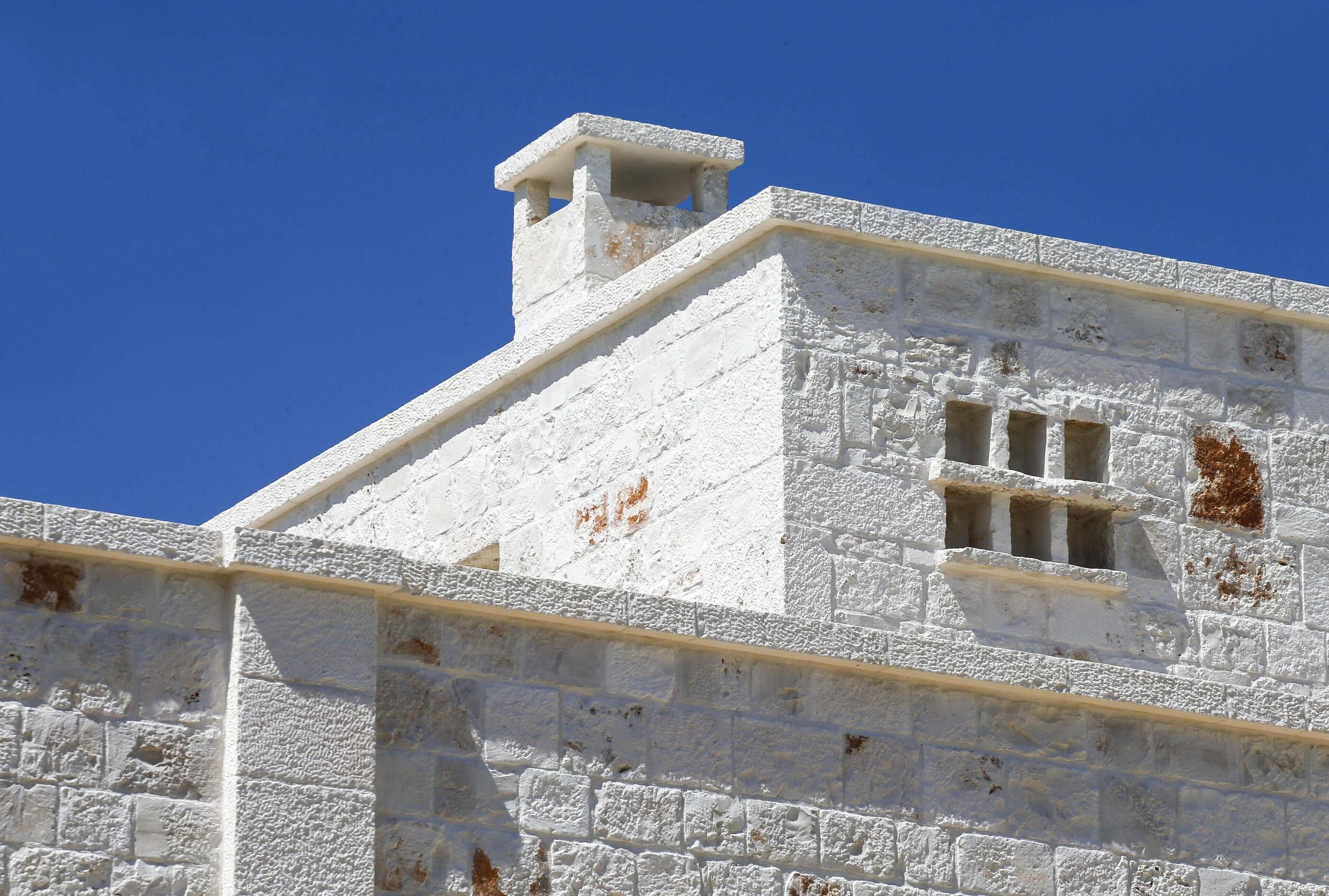 Un bâtiment blanc avec une cheminée et une fenêtre.