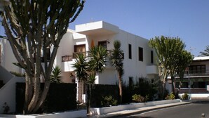 A modern building with a flat roof, white exterior walls, and a balcony. - 2 Bed Ground Floor in small complex and close to all amenities 1 minute seafront (Puerto del Carmen)