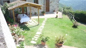 A stone house with a patio, a table set for dining, and potted plants. - Casale Lavinia - country house with swimming pool and magnificent oversight wifi (Lucca)