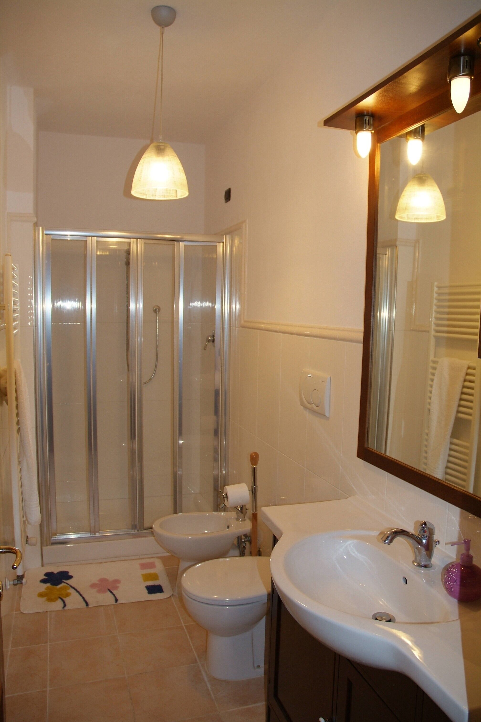 Une salle de bain avec douche, toilettes et lavabo.