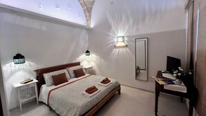 Une chambre à coucher comprenant un lit, des tables de chevet, un bureau, un miroir et une vue sur le ciel, visible à travers le plafond.