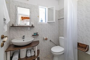 Tina con regadera, secadora de cabello, toallas, papel de baño 