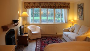 A hotel room with a bed, a sofa, a chair, a TV, and a window with a view of the outside. - Private, spacious, elegant flat with lovely views, in a beautiful area (Westcott)