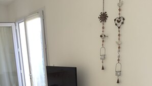 Ein modernes Wohnzimmer mit einem Holz-TV-Schrank, einem Flachbildfernseher und einer Glastür zu einem Außenbereich.