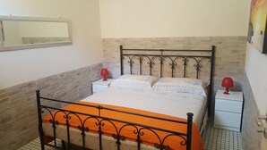 Una camera da letto con un letto, due comodini, uno specchio e un quadro appeso al muro.