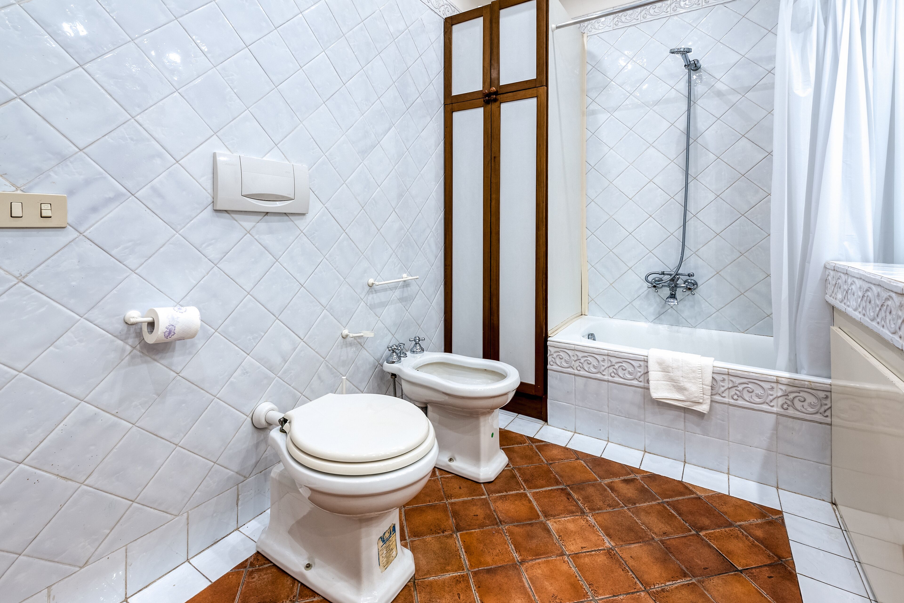 A bathroom with a toilet, bidet, and bathtub.