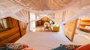 Una habitación con una cama, un sofá, una mesita y una silla.