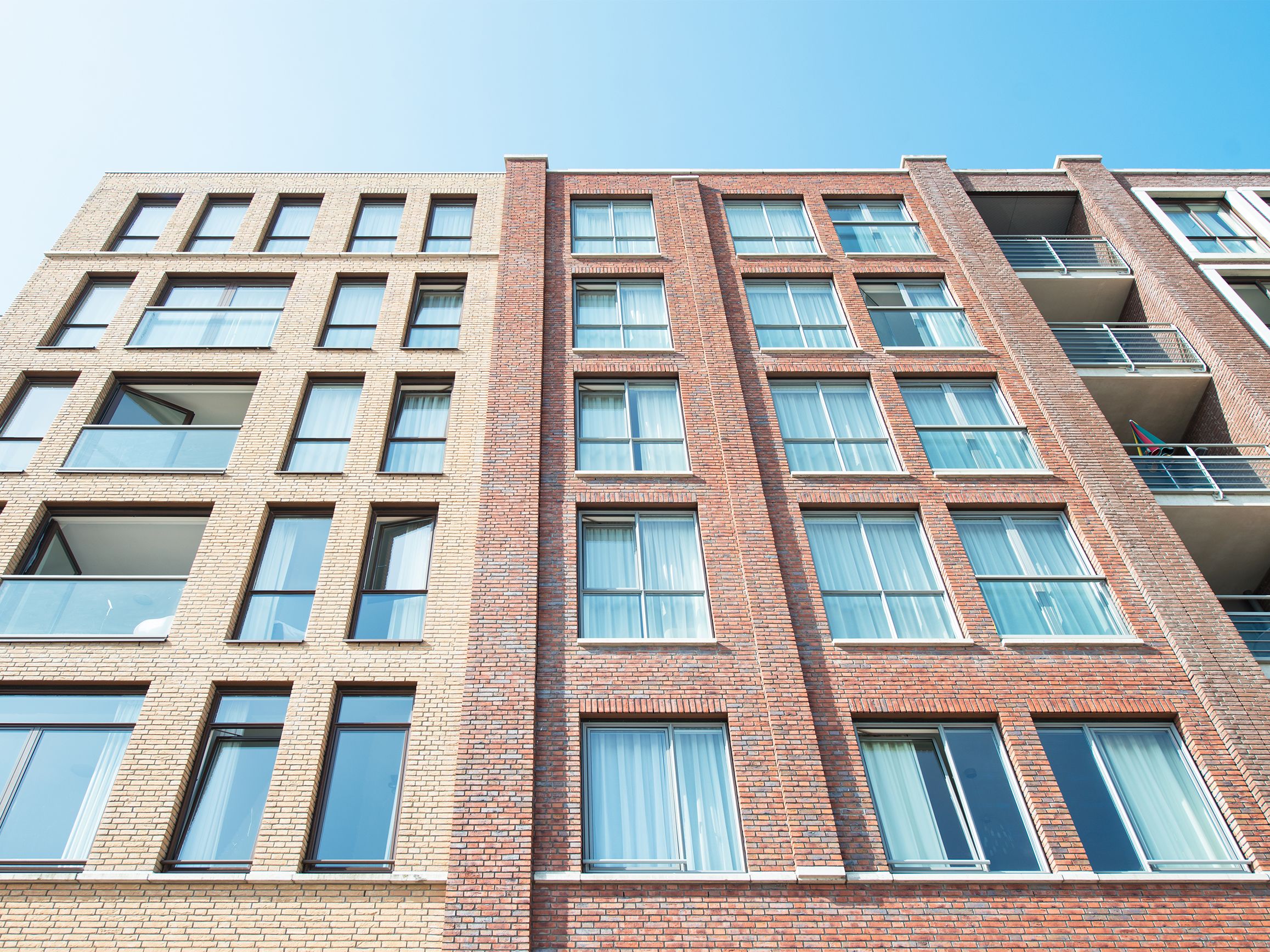 A multi-story building with a brick facade, multiple windows, and balconies.