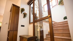 A staircase with a wooden handrail and beige steps, leading to an upper floor.
