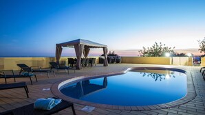 A rooftop pool area with lounge chairs, a covered seating area, and a view of the horizon. - Villa Panoramica | 5 Bedrooms | Panoramic Views | Estói (Estoi)
