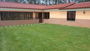 A building with a red-tiled roof, brick walls, and a well-maintained lawn. - Ideal for families with children, has plenty of room to play. Pets accepted (aveiro-vagos)