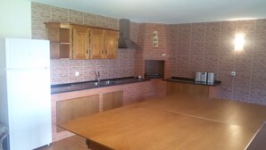 A kitchen with wooden cabinets, a brick backsplash, a large countertop, and a built-in oven. - Ideal for families with children, has plenty of room to play. Pets accepted (aveiro-vagos)