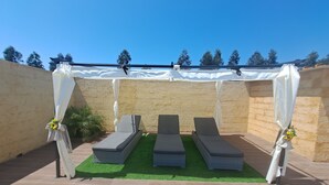 A covered outdoor seating area with three lounge chairs and a white canopy. - Ideal for families with children, has plenty of room to play. Pets accepted (aveiro-vagos)