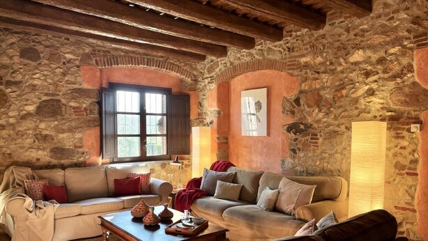 A rustic living room with stone walls, two sofas, a coffee table, and a fireplace. - Costabravapartment Can Marc with private pool and tennis court (Massanes (Girona))
