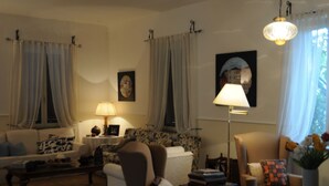 Una sala de estar con sofá, sillones, mesa de centro y lámpara.