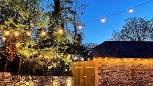 A stone wall with a wooden door, a stone wall with a stone wall, and a stone wall with a stone wall. - Great House nr Polzeath on golf course ideal for families (St Minver, Near Wadebridge)