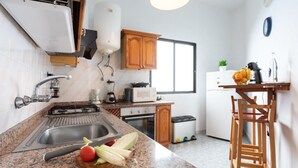 Eine Küche mit Granit-Arbeitsplatten, einem Spülbecken, einem Herd und Holzschränken.