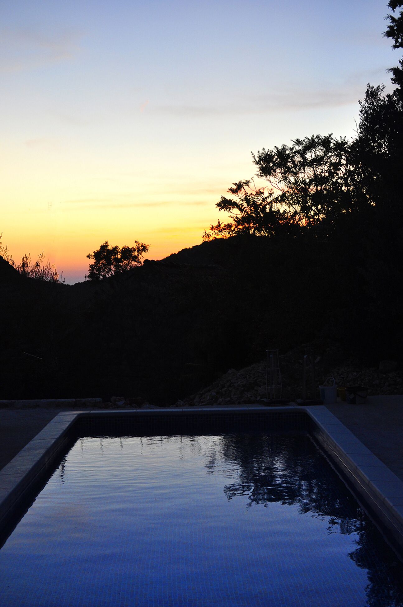 A rectangular swimming pool with clear water reflecting the sky.