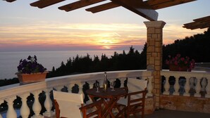 A terrace with a table and chairs, overlooking a scenic view of the sea at sunset. - Special Offer for August  (Corfu)
