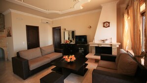 A living room with a sofa, coffee table, and TV. - Special Offer for August  (Corfu)