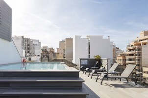 Una piscina al aire libre, tumbonas
