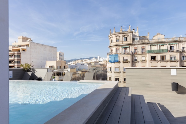 Una piscina al aire libre, tumbonas