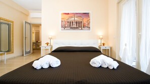 A hotel room with a large bed, two bedside tables with lamps, a painting on the wall, and a view of the city. - House Gregorio, large and comfortable apartment (Roma)