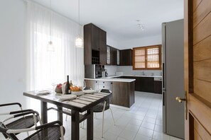 A modern kitchen with dark wood cabinets, a white countertop, and a built-in oven.
