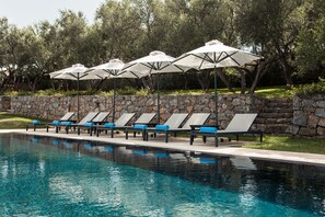 A poolside area with lounge chairs and umbrellas.
