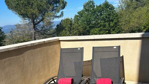 Two reclining chairs with red cushions on a rooftop terrace with a view of trees and mountains. - ALL COMFORT, modern, NICE TERRACE, BEAUTIFUL VIEW of MONT VENTOUX (Bonnieux)