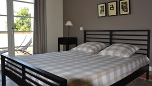 A bedroom with a bed, a nightstand, and a window with curtains. - ALL COMFORT, modern, NICE TERRACE, BEAUTIFUL VIEW of MONT VENTOUX (Bonnieux)