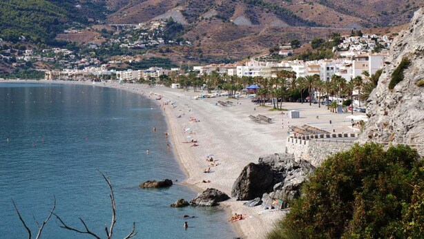A coastal town with a beach, rocky cliffs, and mountains in the background. - Superb location & views, heated pool (Apr - Oct), beach/restaurants 7 mins walk! (Almunecar)