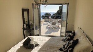 A bedroom with a bed, a mirror, a desk, and a view of the sea through a sliding door. - Superb location & views, heated pool (Apr - Oct), beach/restaurants 7 mins walk! (Almunecar)