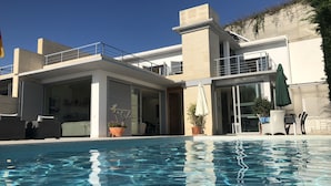 A modern building with a pool, outdoor seating, and potted plants. - Superb location & views, heated pool (Apr - Oct), beach/restaurants 7 mins walk! (Almunecar)