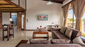 A spacious living room with a wooden ceiling, a large sofa, a coffee table, and a painting on the wall. - Los Arcos dowtown 🌋🌋 (La Fortuna)