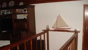 A wooden staircase with a sailboat model on the landing.