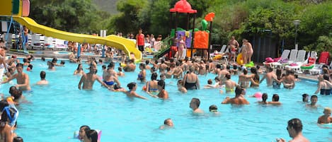 Una piscina al aire libre de temporada, sillones reclinables de piscina