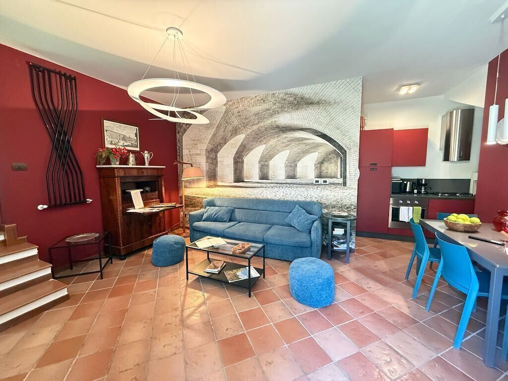 Una sala de estar con chimenea, un sofá, una mesa de centro y un comedor con sillas.