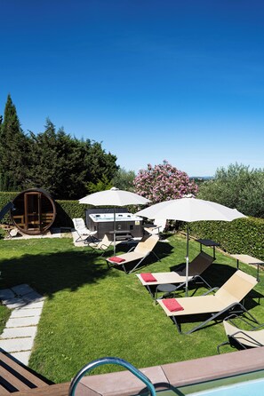 A pool area with lounge chairs, umbrellas, and a hot tub. - Luxury apartment with pool: dolce vita at 15' on foot from the heart of Siena! (Siena)