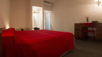 Une chambre à coucher comprenant un lit, un bureau, une chaise et une commode.
