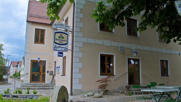 A building with a sign for 'Unterhauser Bier' and a stone well. - Baringer Hof (Neuburg)