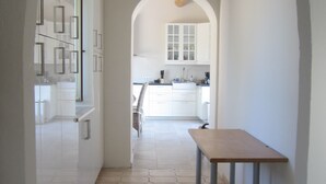 A hallway with a tiled floor leading to a kitchen area. - In peace and quiet: villa with AC, pool, 300 m² terraces in nature reserve (Vidauban)
