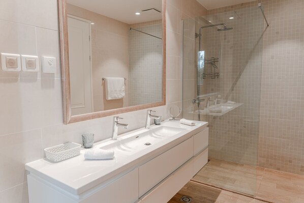 A modern bathroom with a large mirror, two sinks, and a glass-enclosed shower. - Lustica Bay Vacation Homes (Radovici)