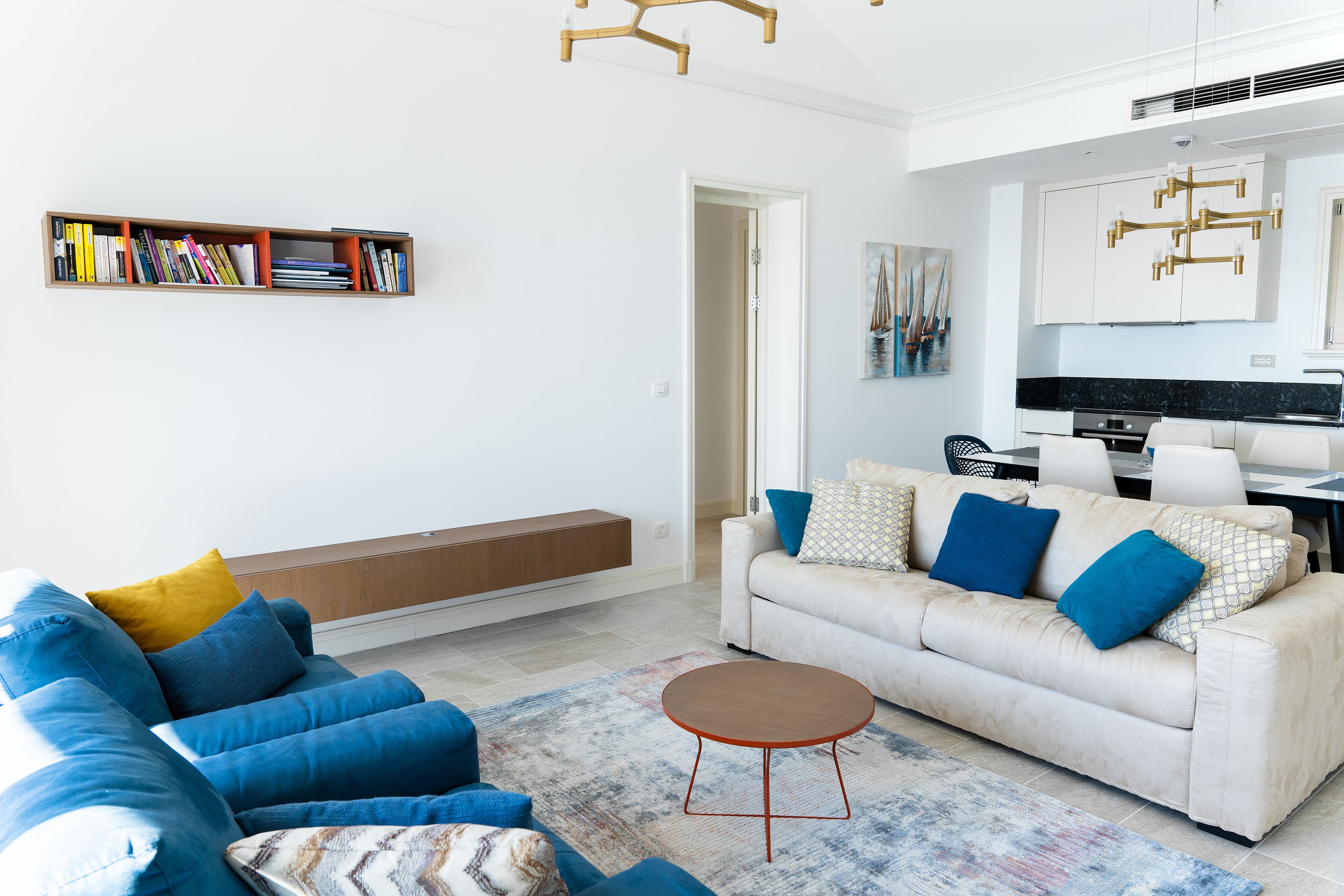 Una sala de estar moderna con un sofá, una mesa de centro y una estantería.