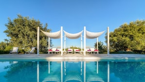 A pool with lounge chairs and a canopy structure. - Raffinata dimora tipica tra ulivi, mandorli e fichi d'india (Ostuni)