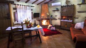 Una sala de estar acogedora con chimenea, muebles de madera y televisión.