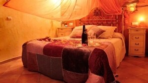 Un dormitorio acogedor con una cama grande, una mesita de noche y un velador.