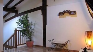 A wooden staircase with a potted plant, a small bench, and a lamp. - Casa Martikonea for 16 people (Basaburua)
