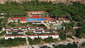 Un complexe hôtelier comprenant plusieurs villas, une piscine et un court de tennis.
