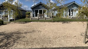 A row of blue cabins with a gravel driveway and a grassy area in front. - Blue Anchor Retreat -  a beach house that sleeps 4 guests  in 2 bedrooms (Filey)